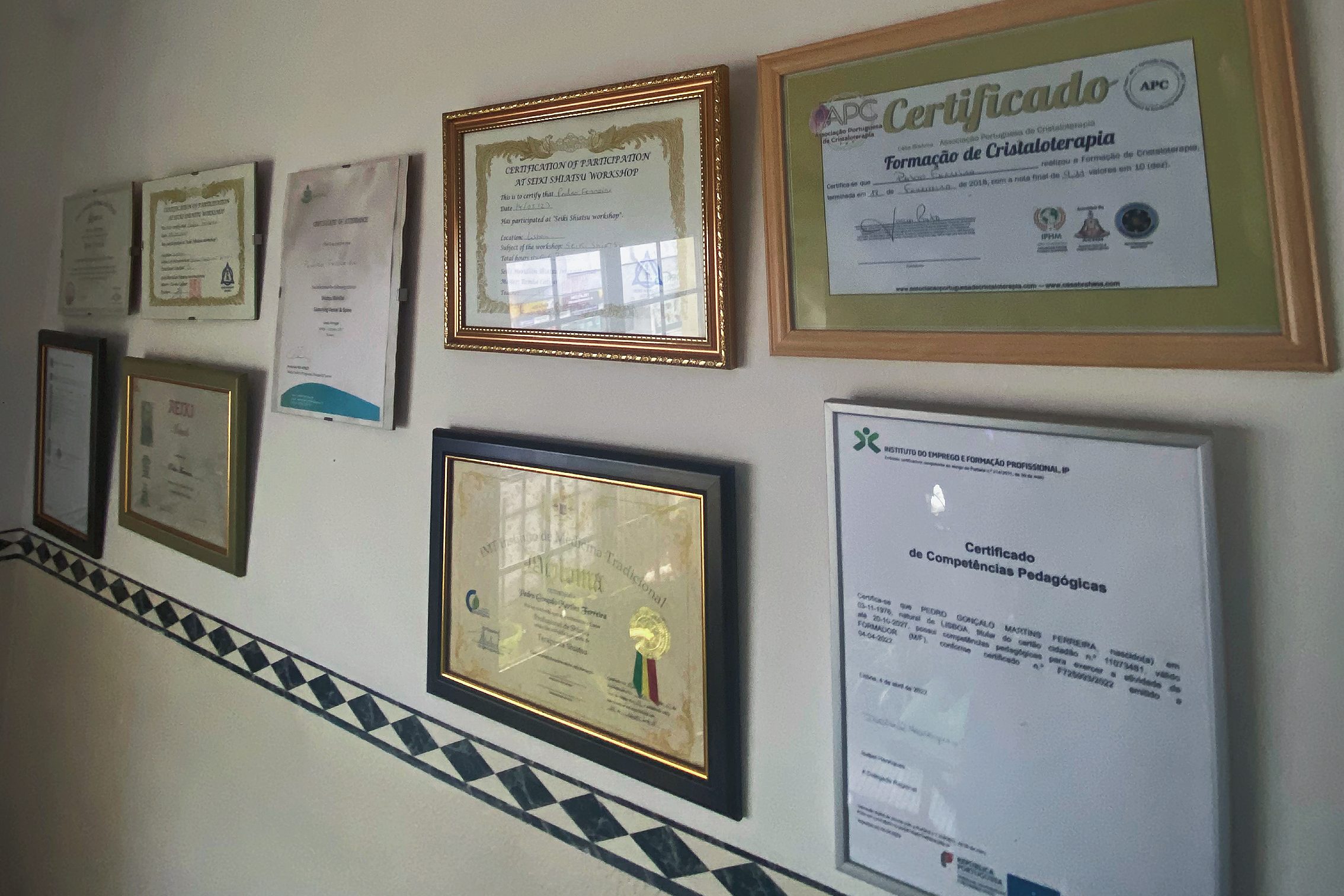 Imagem de uma parede decorada com certificados e diplomas emoldurados, representando as qualificações e formações obtidas ao longo dos anos. Esta imagem reflete o compromisso com o crescimento pessoal e profissional, essencial para criar um espaço como o Terra Ki Terapias, onde se promove o bem-estar, o autoconhecimento e a cura espiritual.